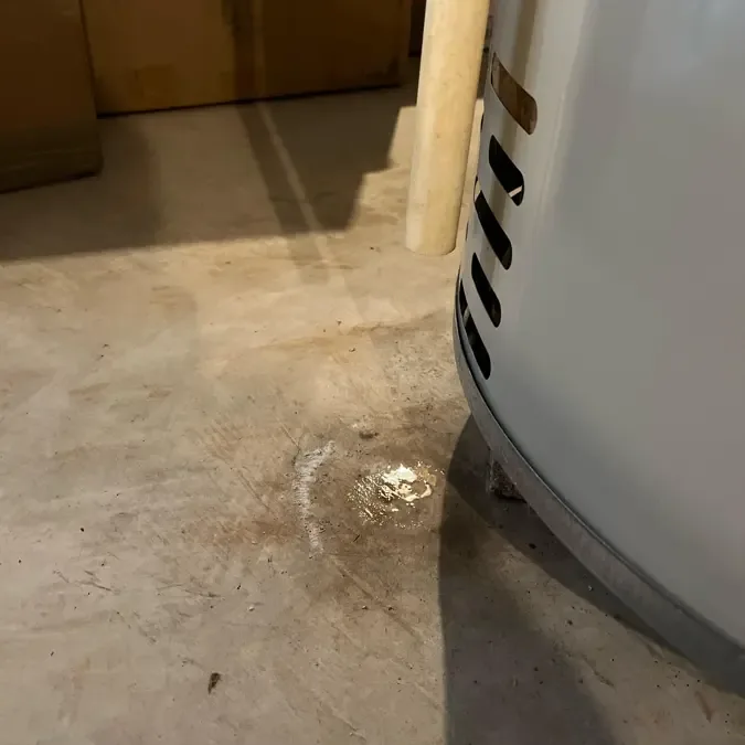 Water pooling beside a leaking garage water heater
